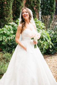 Beautiful bride in timeless wedding dress on wedding day photographed in a garden