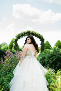 bride walking through greenery arches in fairytale inspired dress