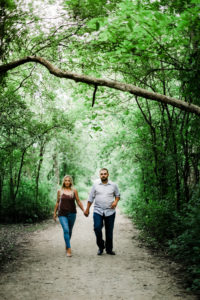Couple walking through green forest preserve