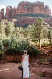 Christy in her elopement dress looking up at Cathedral Rock in Sedona Arizona